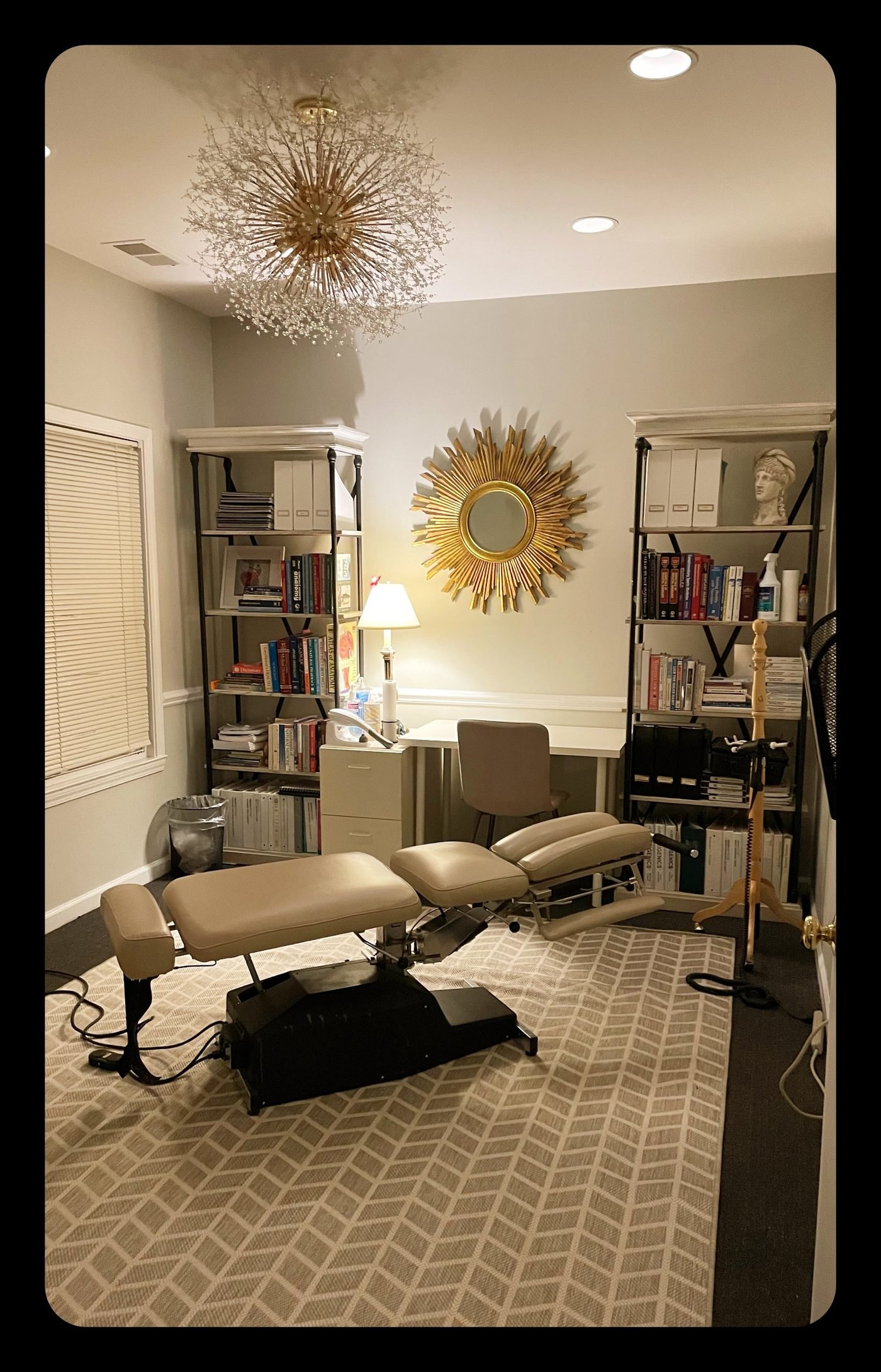 Consultation room with chiropractic table and bookshelves