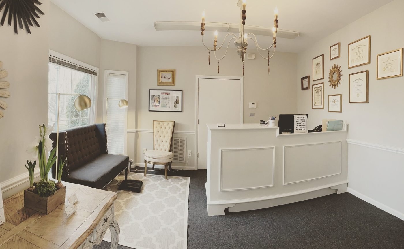 Office lobby with large white desk and doctor's credentials