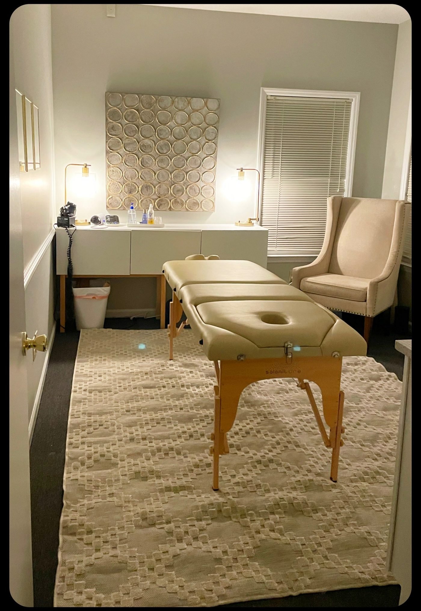 Treatment room with chiropractic table and armchair